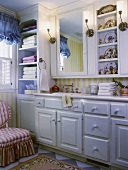 Nostalgic bathroom with white fitted furniture, integrated mirror, shelves of Chinese porcelain and long washstand
