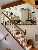 Treppenaufgang in einem Landhaus mit Ablage und Schränkchen für Gartendeko und Gartenutensilien