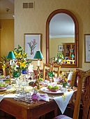 A lavishly decorated dining table with a large curved mirror in the background