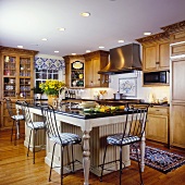 Traditional kitchen with island created to look like dining table and chair-backed bar stools at the counter