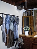 Antike Kleidungsstücke von 1850 hängen dekorativ in einer Küche mit Vintagemöbeln