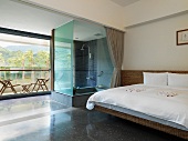 Modern bedroom with glass shower and outdoor patio