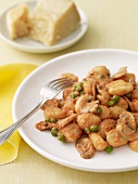 Gnocchi with Peas in a Red Sauce on a White Plate