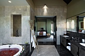 Edles, modernes Badezimmer mit duftendem Blütenbad in der Badewanne