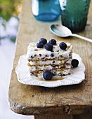 A layered dessert with wafers, stracciatella ice cream and blueberries