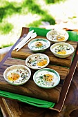 Baked eggs in oven-proof dishes with mushrooms, ham and herbs