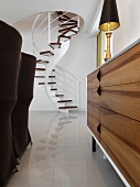 Straight on view of modern spiral staircase through furniture