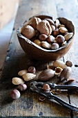 A variety of nuts with a wooden bowl and a nutcracker