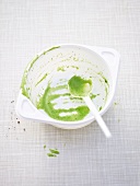 The remains of cream of spinach soup in a soup bowl