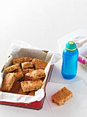 Muesli bars with apricots and honey, a bottle of water and a lunchbox
