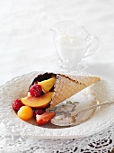 An ice cream cone filled with chocolate and fruits