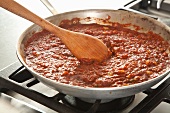 Stirring Pureed Tomatoes into Cooked Vegetables to Make a Chili