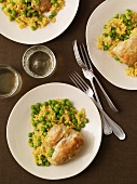 Plates of Chicken Served with Rice and Peas