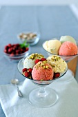 Strawberry, pistachio and cream ice cream in a glass bowl with fruits of the forrest