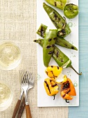 Grilled Stuffed Peppers on a Platter; Glasses of Wine; Forks