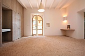 Steinboden aus kleinen Kieselsteinen im minimalistischen Vorraum eines mediterranen Landhauses