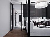 Durch Glaswände abgeteilter Loungeraum im Schwarzweiss-Design mit Teetablett auf Megasofa