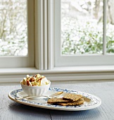 Vanilla ice cream with caramel drizzle and sesame crackers on a windowsill