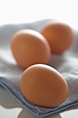 Drei braune Eier auf Tuch