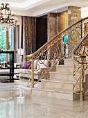 Treppe mit Marmorstufen und verziertem Messinggeländer in der Vorhalle einer eleganten Villa