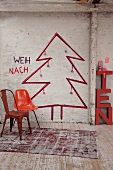 Retro Stühle vor skizziertem Weihnachtsbaum an Wand in rustikalem Ambiente