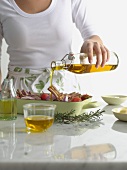 Woman pouring olive oil over roast dish
