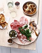 Plate of sliced meats, bread and herbs