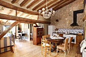 Kitchen and dining area under historical roof structure of open-plan interior