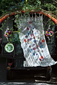 Wafting curtain with appliqué floral motifs and colourful crocheted trim decorating vehicle