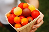 Woman Holding a Small Wooden Carton of Heirloom Tomatoes