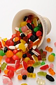 Various sweets falling out of a cup