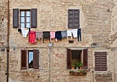 Wäsche hängt an der Leine vor einer Hauswand