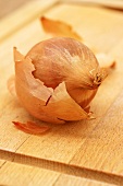 An onion on a wooden chopping board