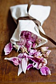 Dried rose petals falling out of a linen sack