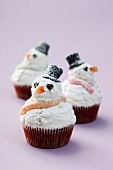 Snowman cupcakes on a purple surface