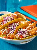 Tacos filled with baked fish and cabbage salad