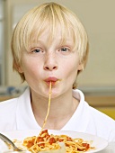 A Boy eating Pasta