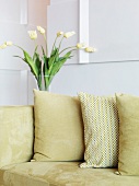 Pillows on an a couch upholstered in light-colored velvet