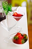 Strawberry martini in cocktail glass with strawberry on cocktail stick