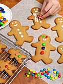 Gingerbread men being decorated with chocolate beans