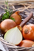 A basket of onions, whole and halved