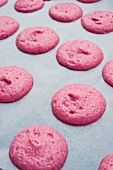 Piles of pink macaroon dough on baking paper