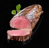 Roast beef fillet on a black surface