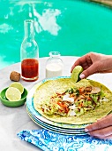 A chicken wrap being drizzled with lime juicce