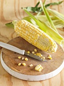 A corn cob on a chopping board