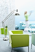 Wohnraum in Aquafarben mit grünem Sessel & Designer-Edelstahlleuchte