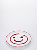 A ketchup smiley on a plate