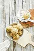 Bread dumplings in a bowl and on a draining spoon