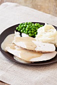 Slices of Turkey Cooked in a Slow Cooker on a Plate with Gravy and Mashed Potato
