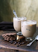 Two Glasses of Iced Coffee with Cinnamon Sticks, Coffee Beans and Cookies
